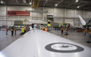 Australia’s first MQ-4C Triton fuselage is lowered onto the unique one-piece wing. Northrop Grumman image.